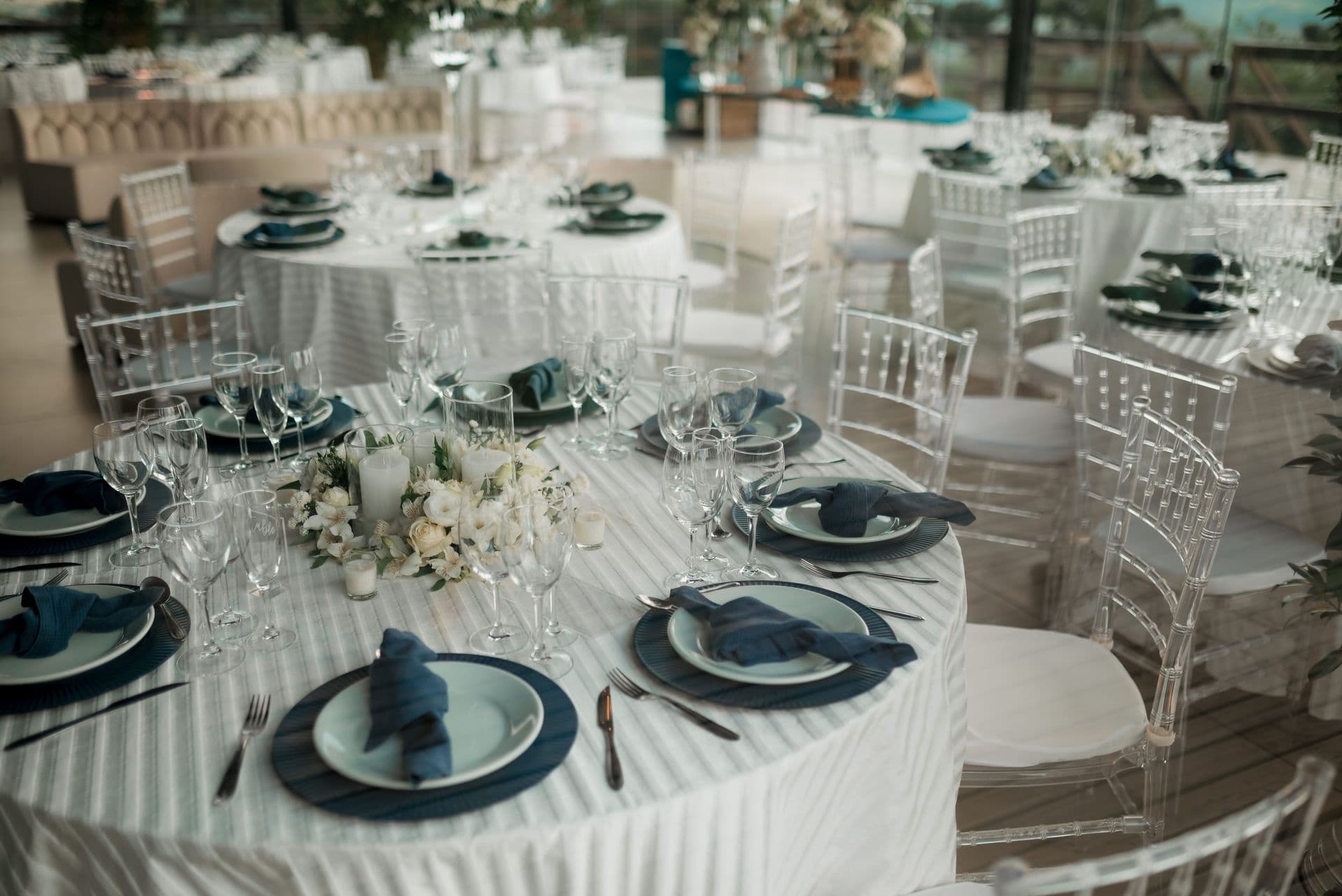 Overhead view of a white-linen reception room before guests arrive
