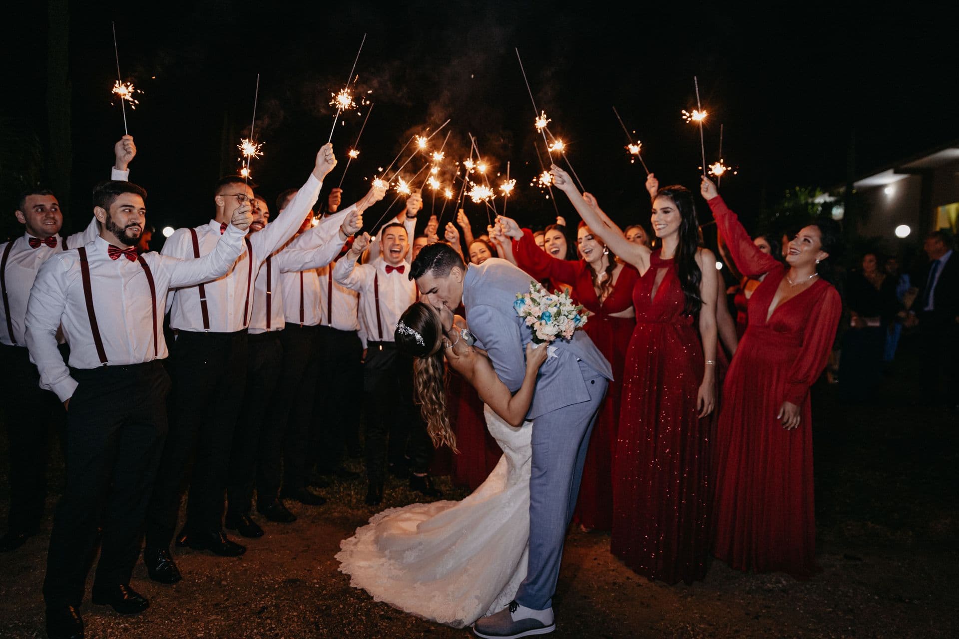 Night-time sparkler exit with the wedding party cheering